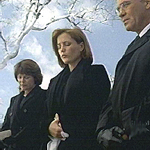 Scully’s mother stands to her right. Skinner to her left.